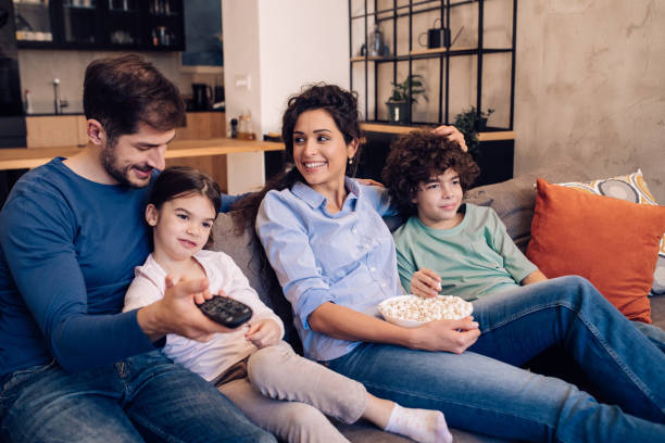 istock Family spending weekend evening with TV 1245463811