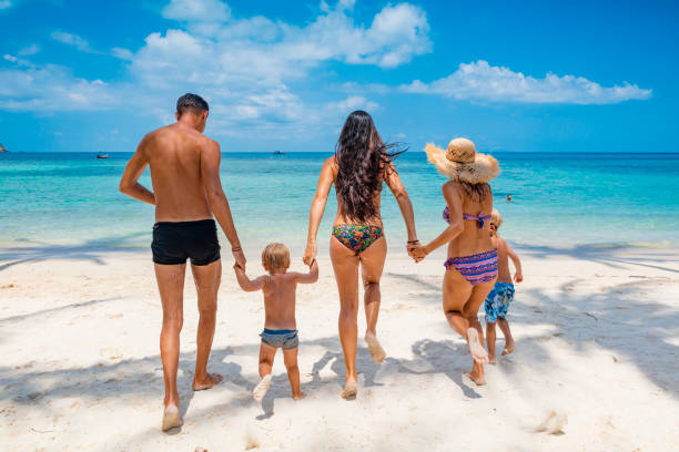 istock Friends playing in waves on beach 1245463846