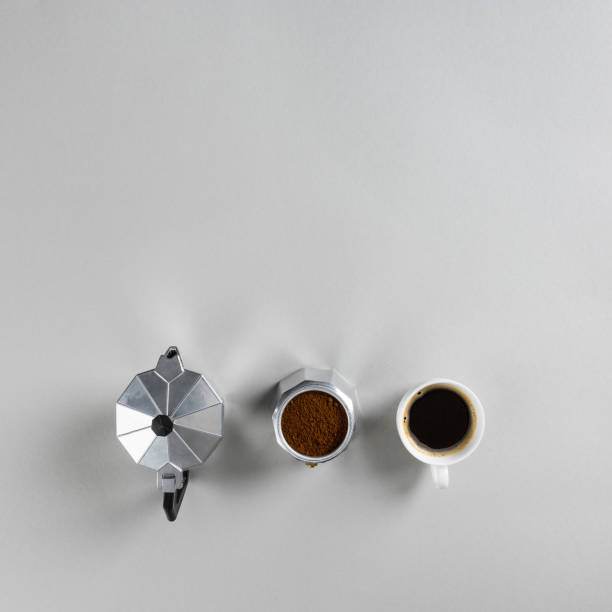 istock Top view of disassempled moka coffee maker and cup on grey background 1245464451
