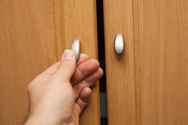 hand opening the closet door