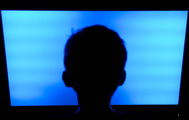 Silhouette of a child's head in front of a flat screen TV Boy (9 years) looking at the typical blue screen of a flat screen television. Focus is on the TV. broken flat screen stock pictures, royalty-free photos & images