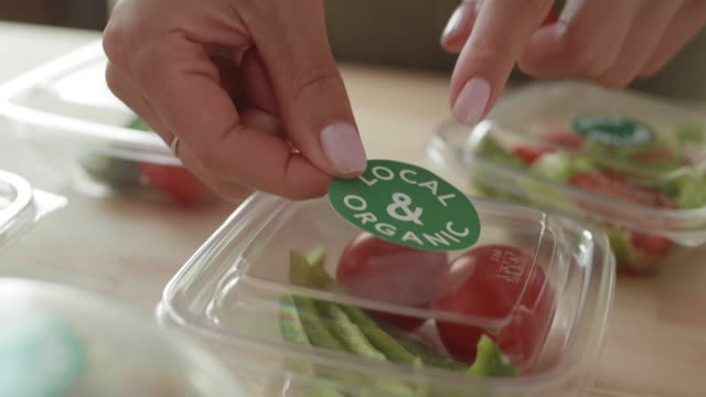 Female Hands Sticking Stickers on Food Boxes
