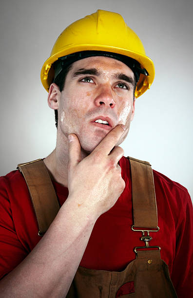 istock Thoughtful worker in hard hat and overalls 124550881