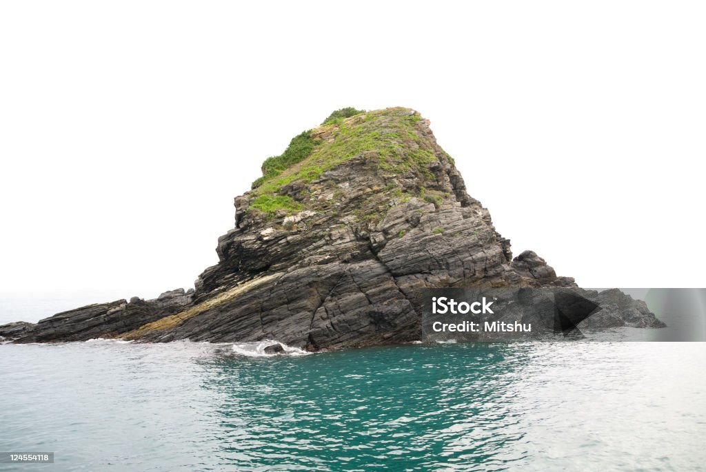 Single rock in the calm sea Single rock in the calm sea, the horizon disappears in the fog. Absence Stock Photo