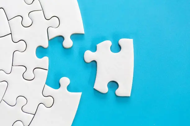 Photo of White jigsaw puzzle pieces on a blue background. Problem solving concepts. Texture photo with copy space for text
