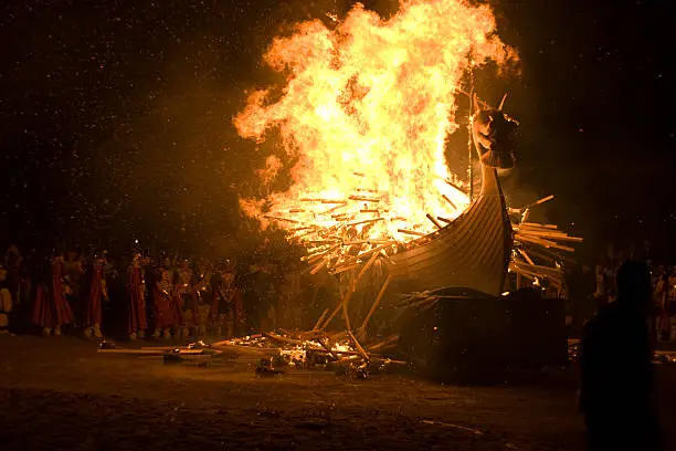 The Up Helly Aa burning galley ship filled with hundreds of burning torches surrounded by vikings.