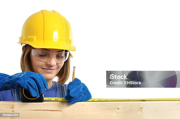 Construction Contractor Carpenter Woman Measuring Two By Four On White Stock Photo - Download Image Now