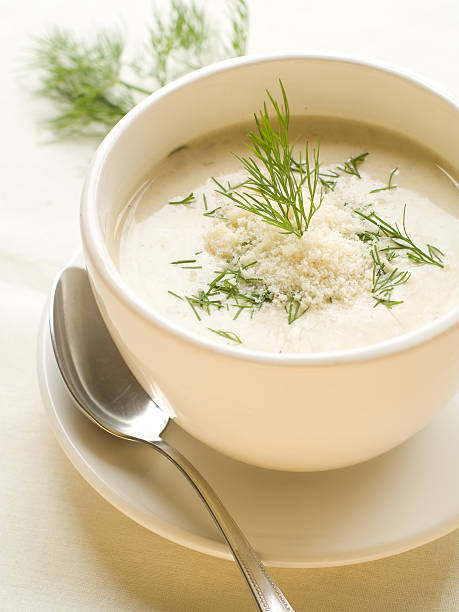 Bowl of vegetable soup on a plate with a spoon