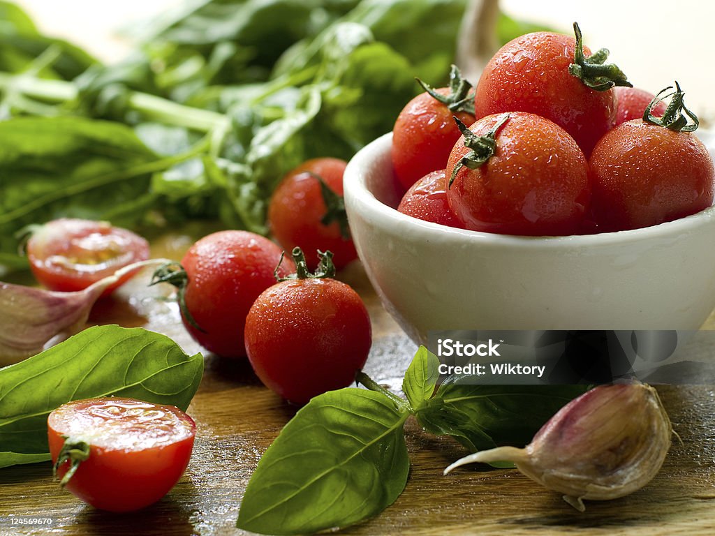 Cherry tomatoes Cherry tomatoes  in a bowl with basil and garlic Basil Stock Photo