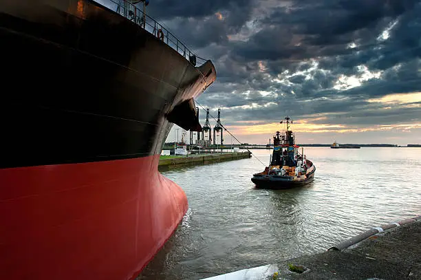 Tug boat taking out the ship from the harbor