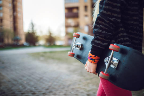 Young caucasian woman with skateboard in hands.