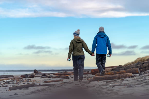 istock Young couple walk across beach holding crystal spheres 1245735300