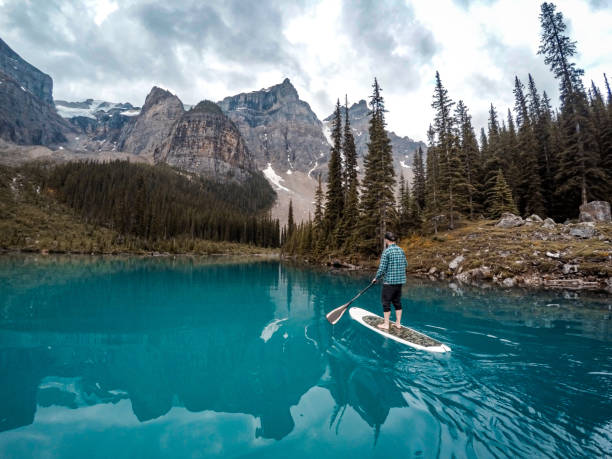 istock Man paddle-boards across Moraine Lake, Banff NP 1245756319