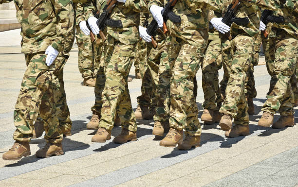 istock Soldiers marching with machine guns 1245789945