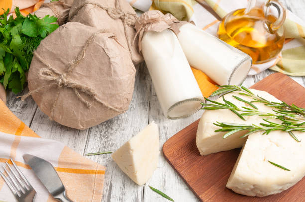 istock Adyghe cheese cut off a triangular piece. Cheese on a wooden board. Decorated with a branch of rosemary. 1245794852