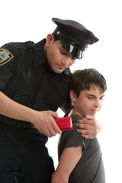 Police officer with teen juvenile delinquent A policeman with a male juvenile delinquent that has stolen an electronic device. item child arrest stock pictures, royalty-free photos & images