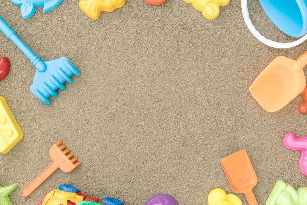 Children's sandbox with various toys for the game. Sand yellow background. Concept of a family vacation near the sea with children