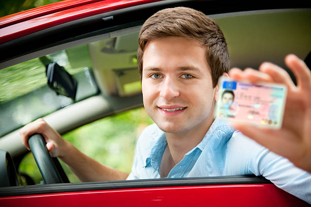 drivers license teenager sitting in new car and shows his drivers license driving licence stock pictures, royalty-free photos & images