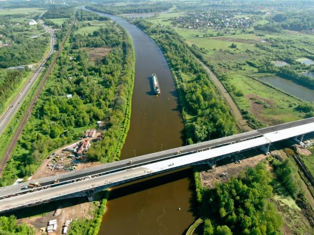 istock Beautiful panoramic landscape from high altitude cargo commercial ship sails down river surrounded by green forest in summer with sunny day 1245809158