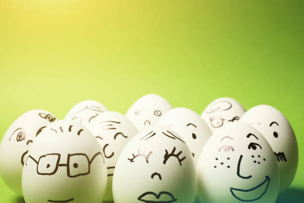 istock Drawing of Faces on Many Eggs with Green Background 1245822304