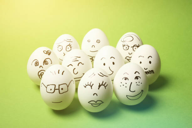 istock Drawing of Faces on Many Eggs with Green Background 1245822321