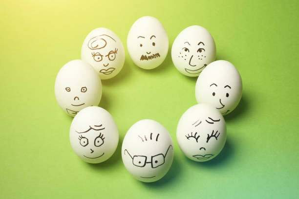 istock Drawing of Faces on Many Eggs with Green Background 1245822850