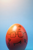 istock Drawing of Devil Face on an Egg with Blue Background 1245823402