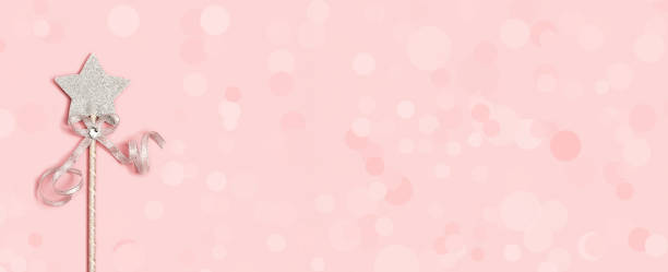 istock Festive decoration, magic wand, bright silver star with shine on soft pink background with copy space. Minimal holiday concept. Banner for website. 1245823591