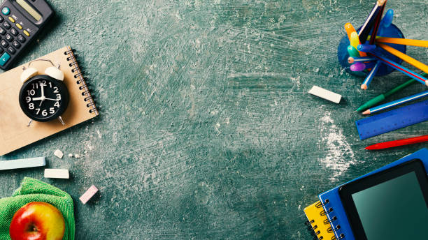 istock Concept back to school on schedule. alarm clock, notebooks, pencils, student or student tools on Green Blackboard Background for chalk. top view 1245871812