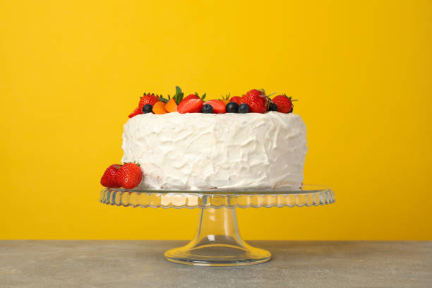 istock Berry cream cake against yellow background. Delicious dessert 1245877173