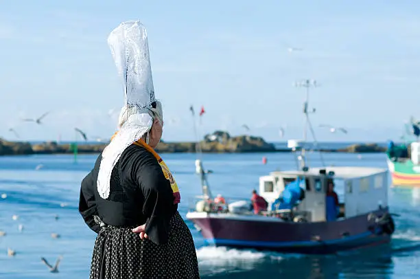breton women with headdress on a harbor in brittany