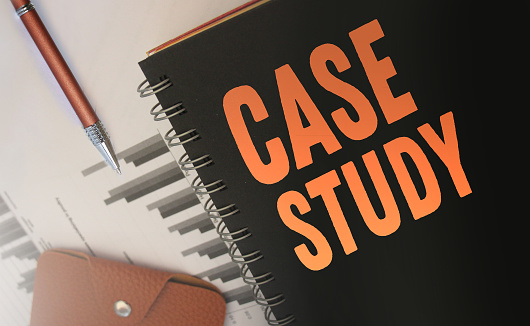 Case studies text written on a diary cover orange on black. Business concept. Selective focus