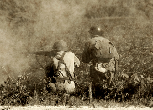 Two soldiers in a  World War II era battlefield. (Present day photo with artificially aged effect using software)