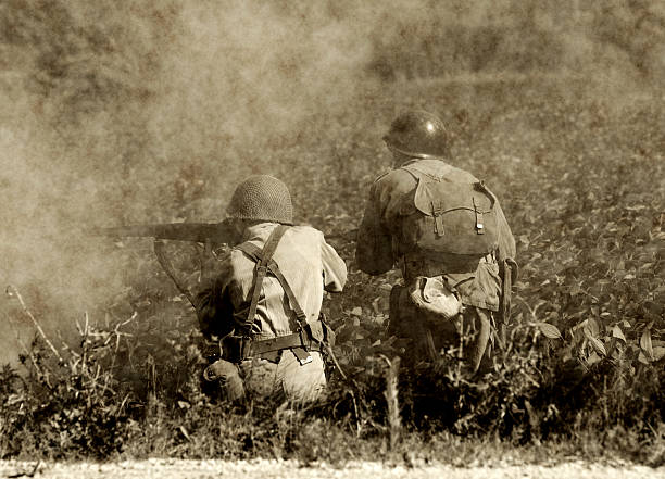 World War II soldiers in battle Two soldiers in a  World War II era battlefield. (Present day photo with artificially aged effect using software) war photos stock pictures, royalty-free photos & images