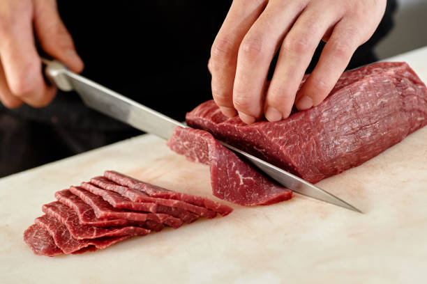Japanese man slicing meat Japanese man slicing meat meat packing industry photos stock pictures, royalty-free photos & images