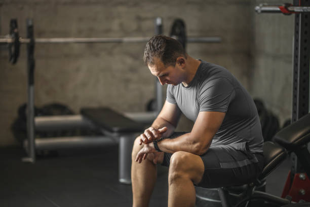 istock Sports man setting his smart watch before training in gym 1245908772