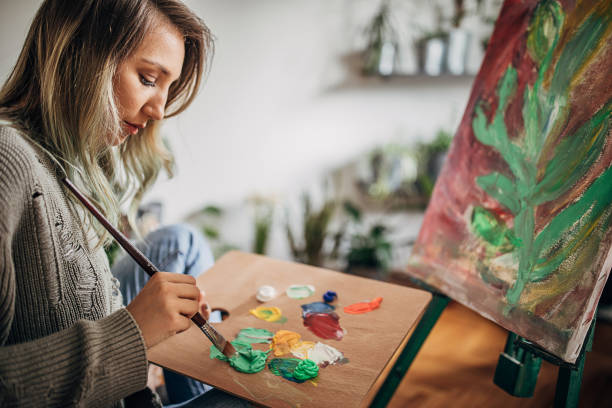 istock One young woman painting on a canvas in her home studio 1245908851