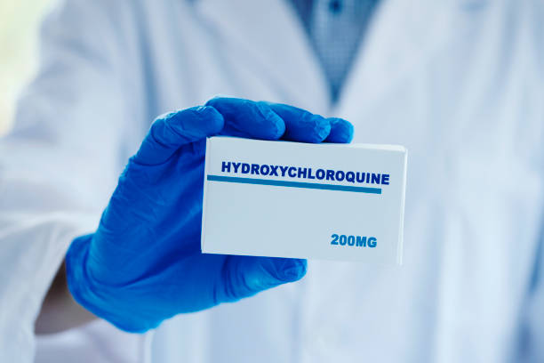istock man in white coat with a box of hydroxychloroquine 1245909175