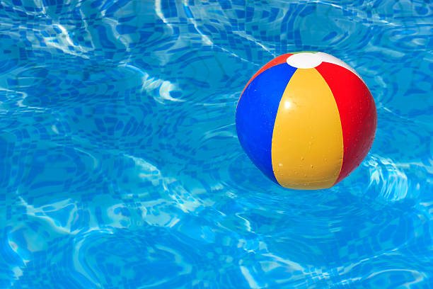 A colorful beach ball floating in a blue swimming pool