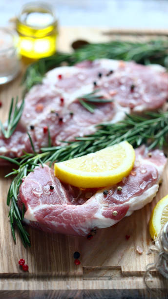 istock Raw meat steaks with lemon and rosemary. 1245923820