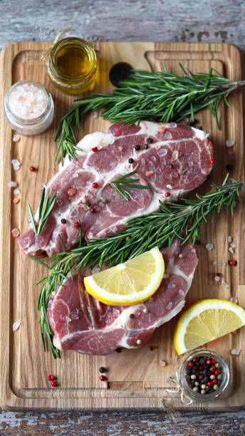 istock Raw meat steaks with lemon and rosemary. 1245923825