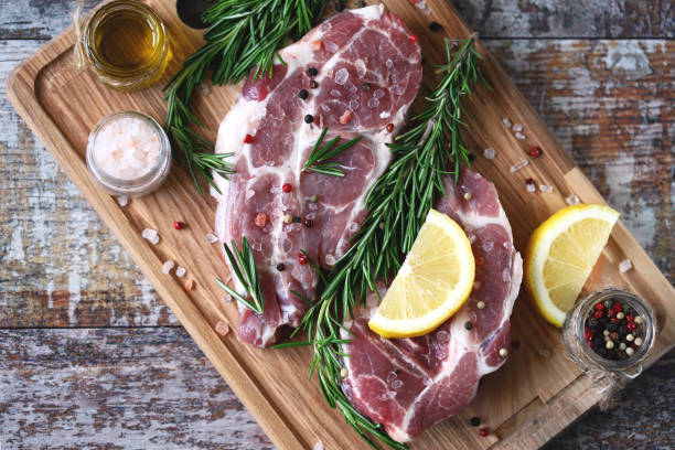 istock Raw meat steaks with lemon and rosemary. 1245923827