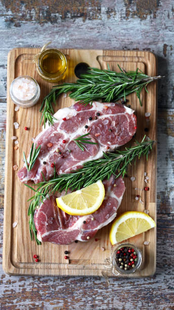 istock Raw meat steaks with lemon and rosemary. 1245923834