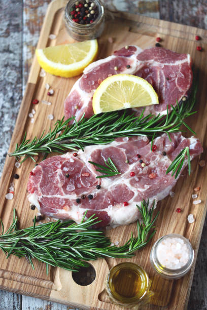 istock Raw meat steaks with lemon and rosemary. 1245923848