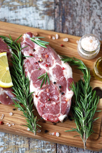 istock Raw meat steaks with lemon and rosemary. 1245924189