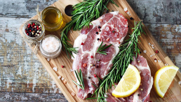 istock Raw meat steaks with lemon and rosemary. 1245924348