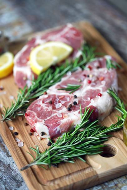 istock Raw meat steaks with lemon and rosemary. 1245924352