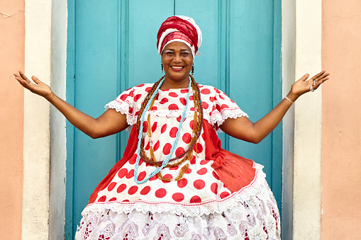 Brazilian woman of African descent wearing traditional Baiana costume in the historic Center of Salvador, Bahia, Brazil.