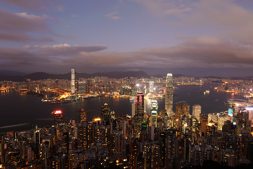 aerial view of victoria harbor with many iconic landmarks and skyscrapers with high rise apartment blocks at night,Hong Kong,China.