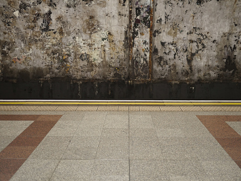 Empty Underground Train Station Platform with Tiled Floor. Showing yellow warning lines.